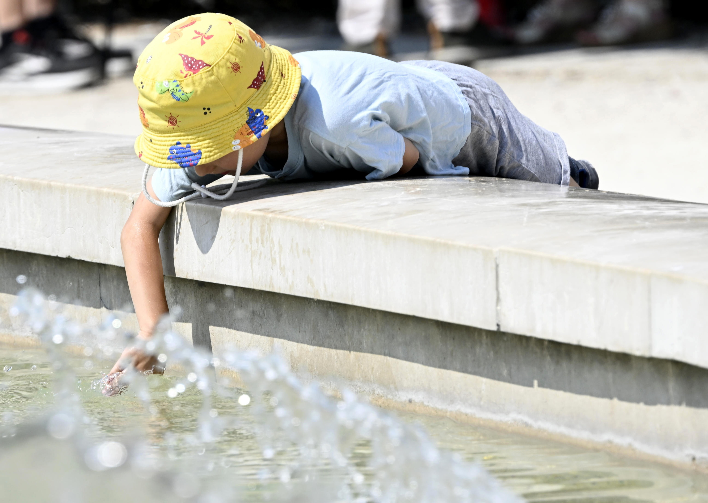 Ume bat Milanen, plaza bateko iturrian freskatzen. DANIEL DAL ZENNARO / EFE