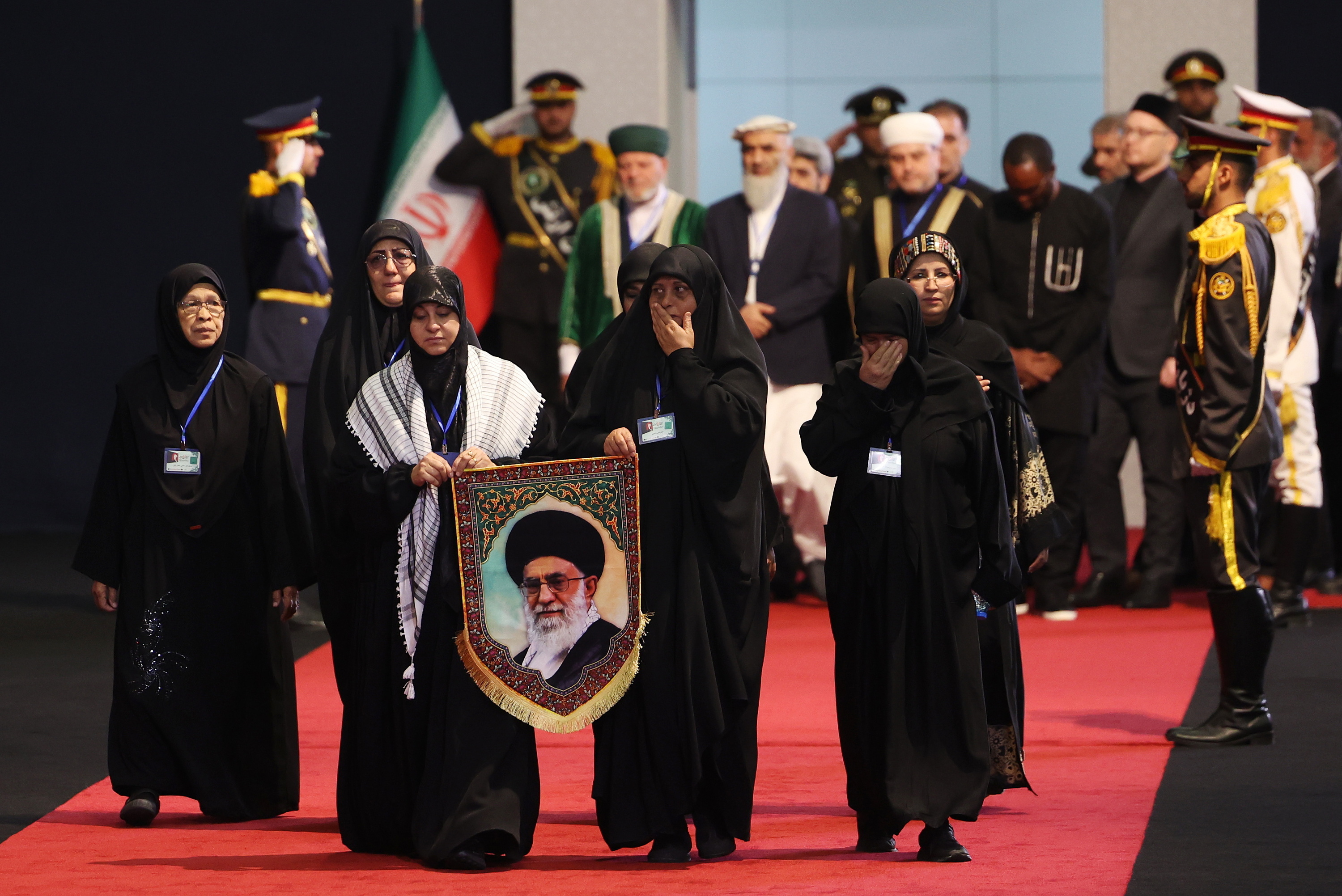 Emakume batzuk Teherango Mosalla meskitan sartzen gaur, eskuetan Ali Khameneiren argazki bat daramatela. ABEDIN TAHERKENAREH / EFE