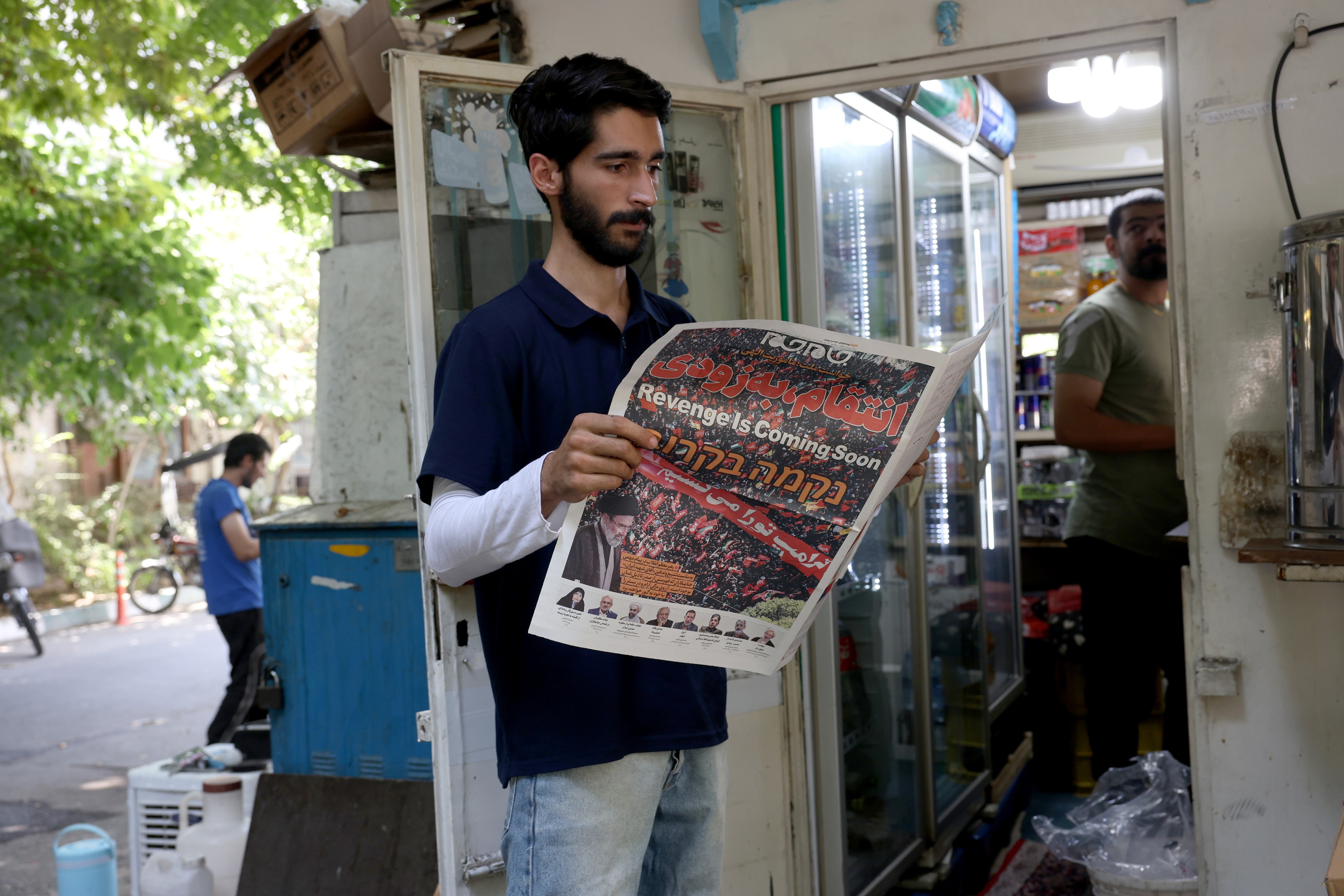 Irango herritar bat egunkari bat irakurtzen, atzo, Teheranen. Egunkariaren titularra: «Mendekua laster iritsiko da». ABEDIN TAHERKENAREH / EFE