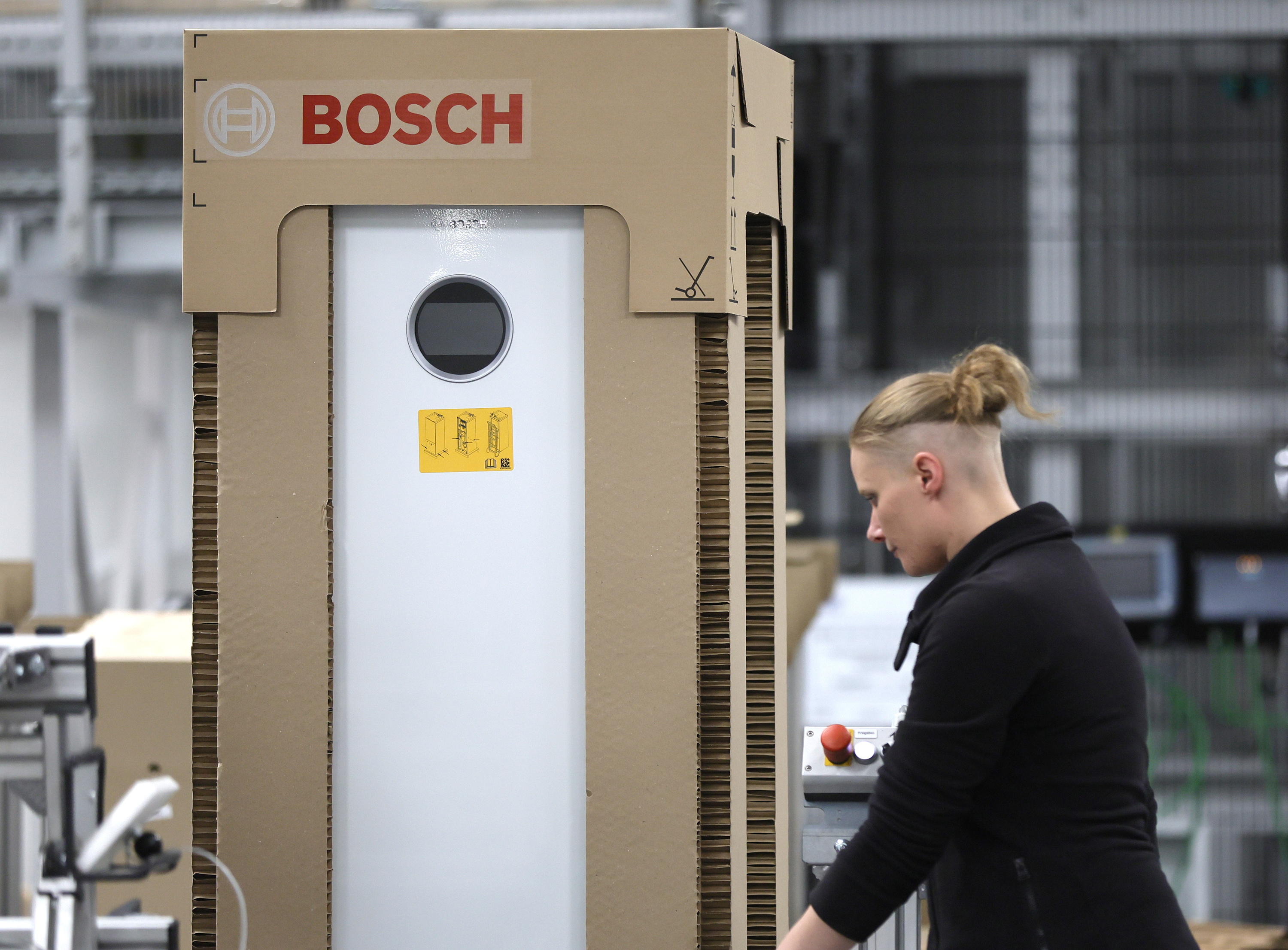 Bosch fabrikako langile bat, bero ponpa baten zati bat egiten. RONALD WITTEK / EFE