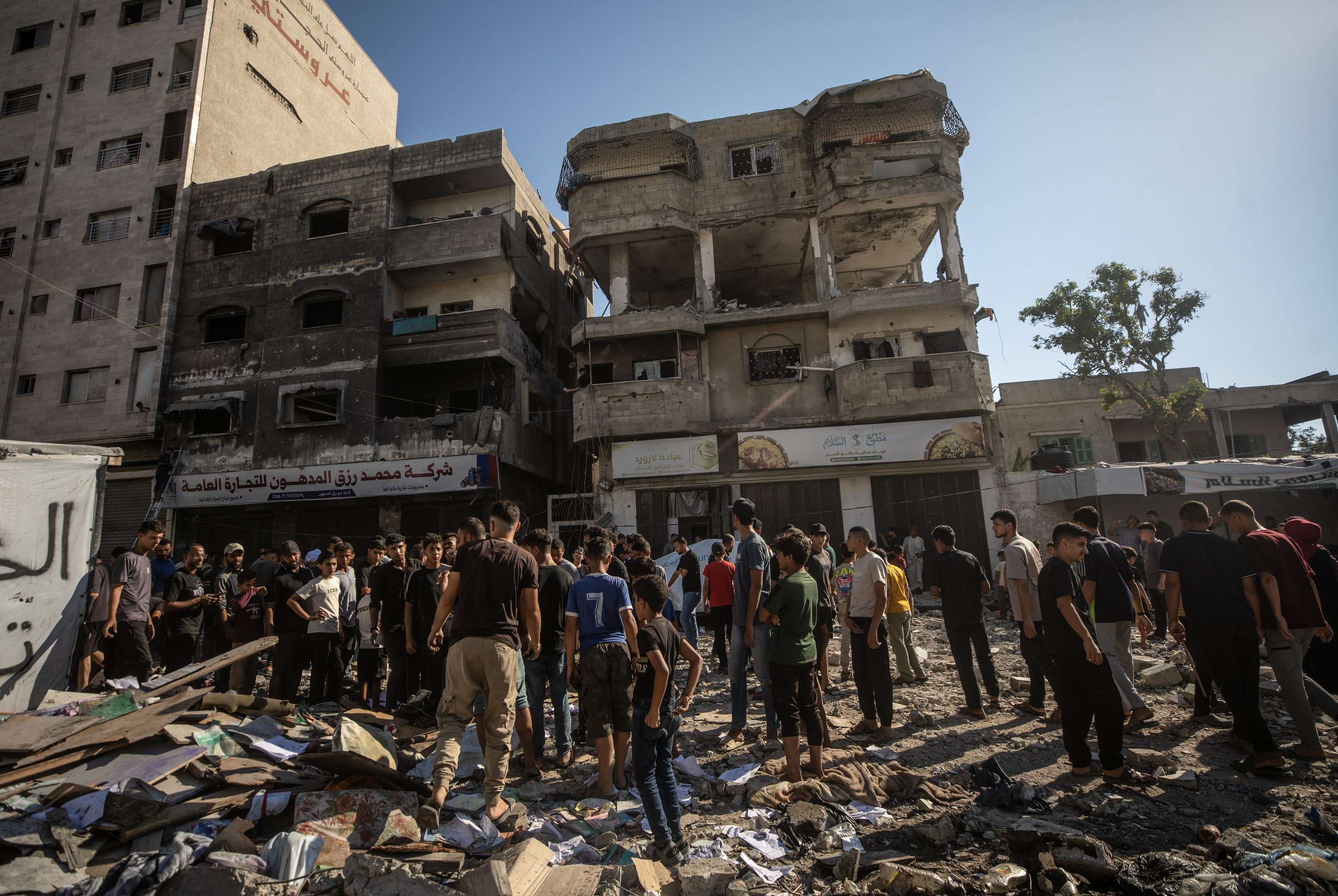 Hainbat palestinar Israelen erasoek birrindutako eraikinen inguruan uztailaren erdialdean, Gaza hirian. MOHAMMED SABER / EFE