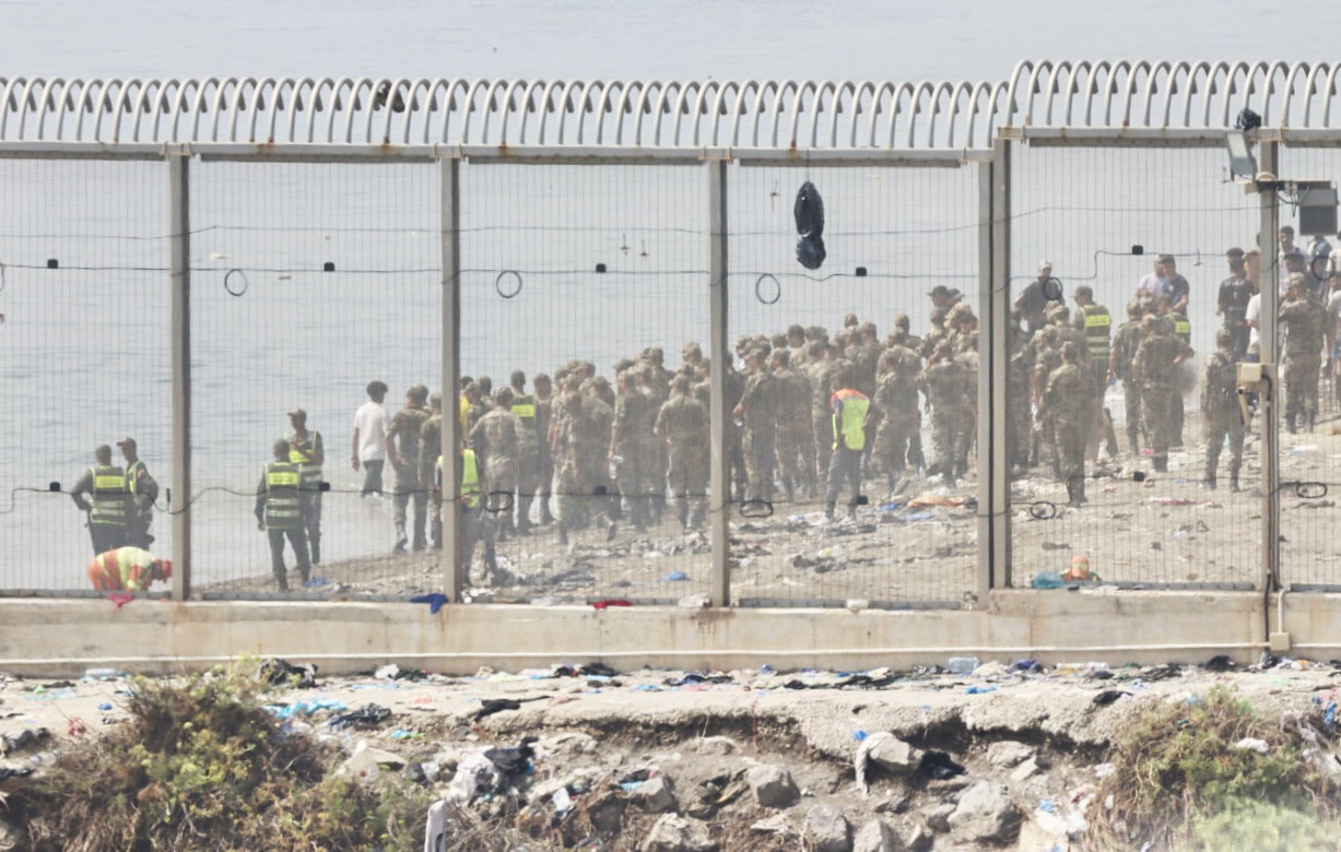 Marokoko indarrak migratzaileak Espainiaren eta Marokoren arteko mugan geldiarazten, gaur, Ceutan.  EFE