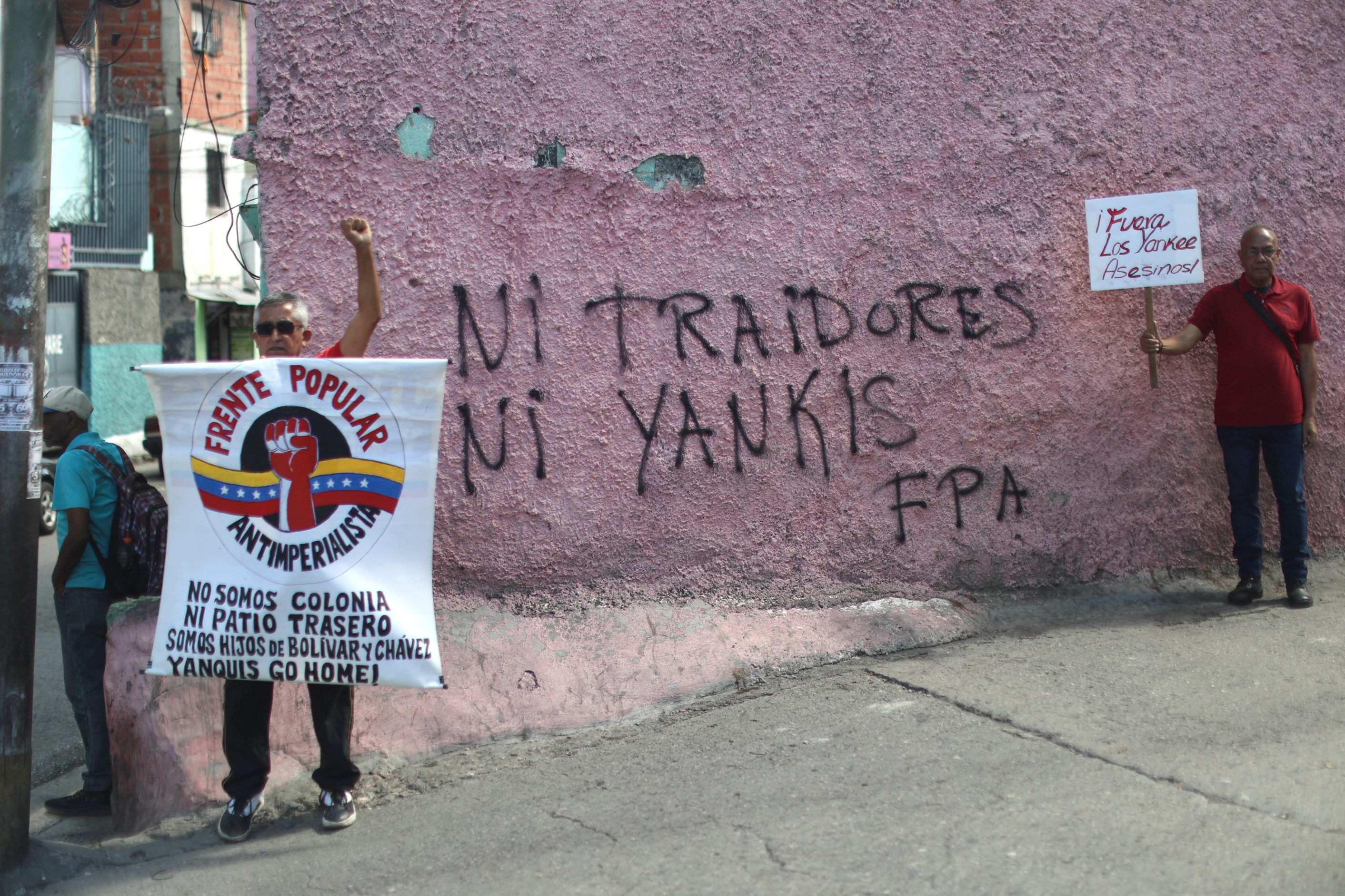 Bi manifestari Caracasen, iragan larunbatean, AEBen aurkako pintada baten aldamenean. MIGUEL GUTIERREZ / EFE