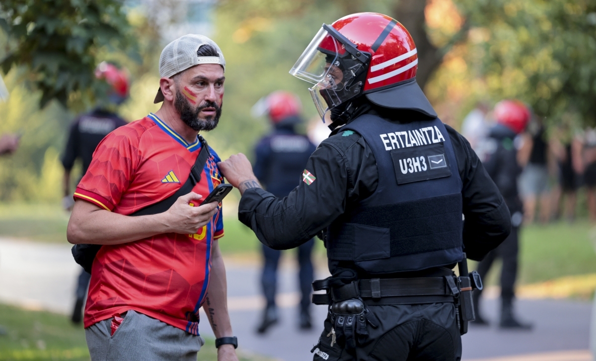 Espainiaren zale bat, Ertzaintzarekin hizketan, Bilbon, Casilda Iturrizar parkean jarritako pantailaren eremuan. LUIS TEJIDO / EFE 