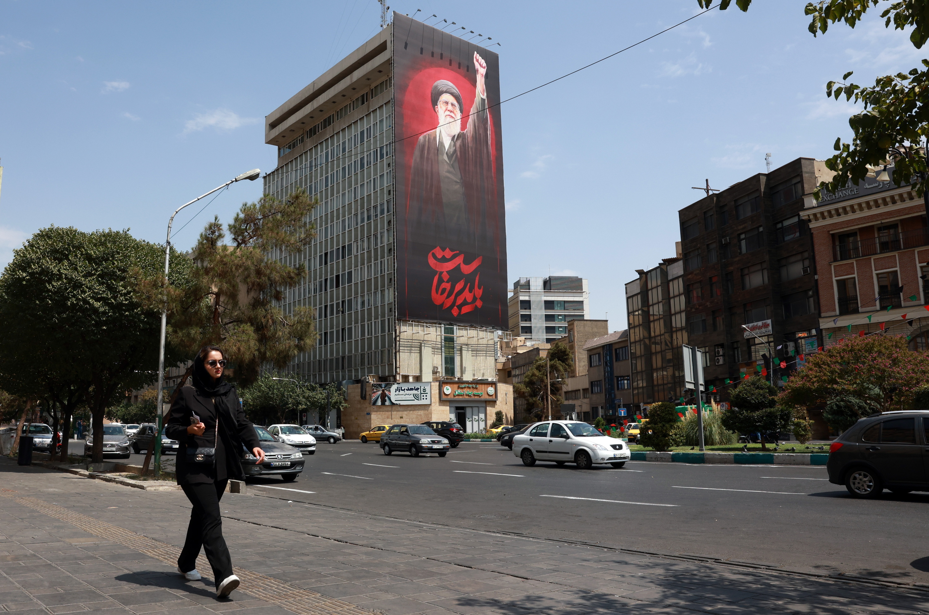 Emakume bat atzo, Teheranen, atzean Ali Khamenei lider gorenaren irudia duela. ABEDIN TAHERKENAREH / EFE