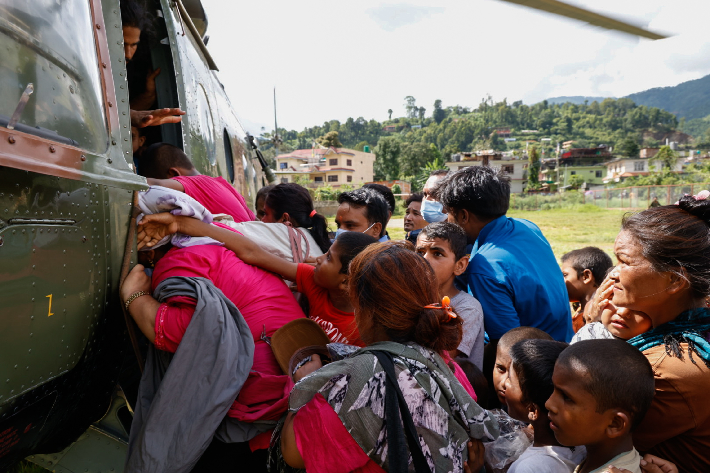 Nepalgo herritar batzuk, herrialdeko armadaren helikoptero batean sartzen saiatzen, Hatigauda herrian, gaur. NARENDRA SHRESTHA / EFE