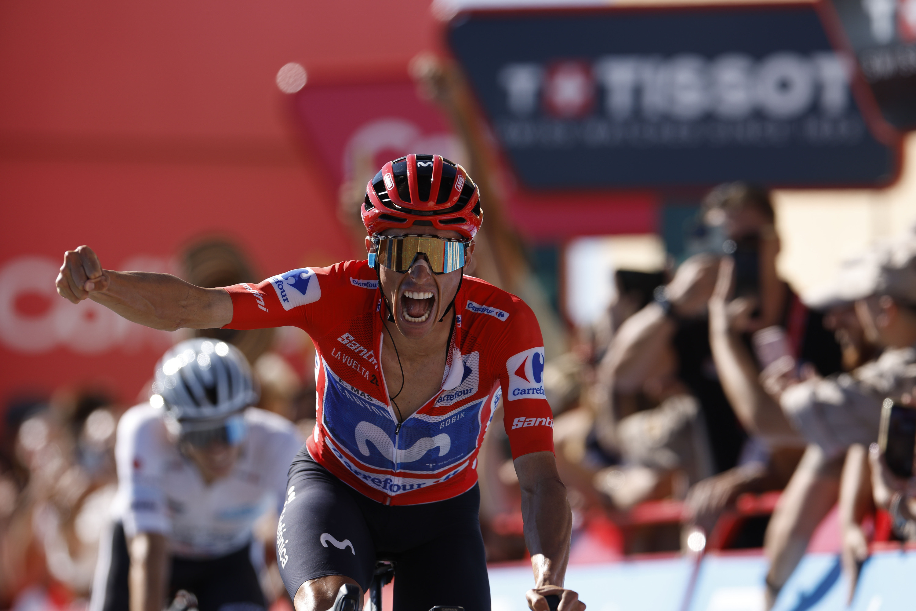 Enric Mas garaipena ospatzen, gaur, Aitanako gainean. Atzean, Onley. JAVIER LIZON / EFE