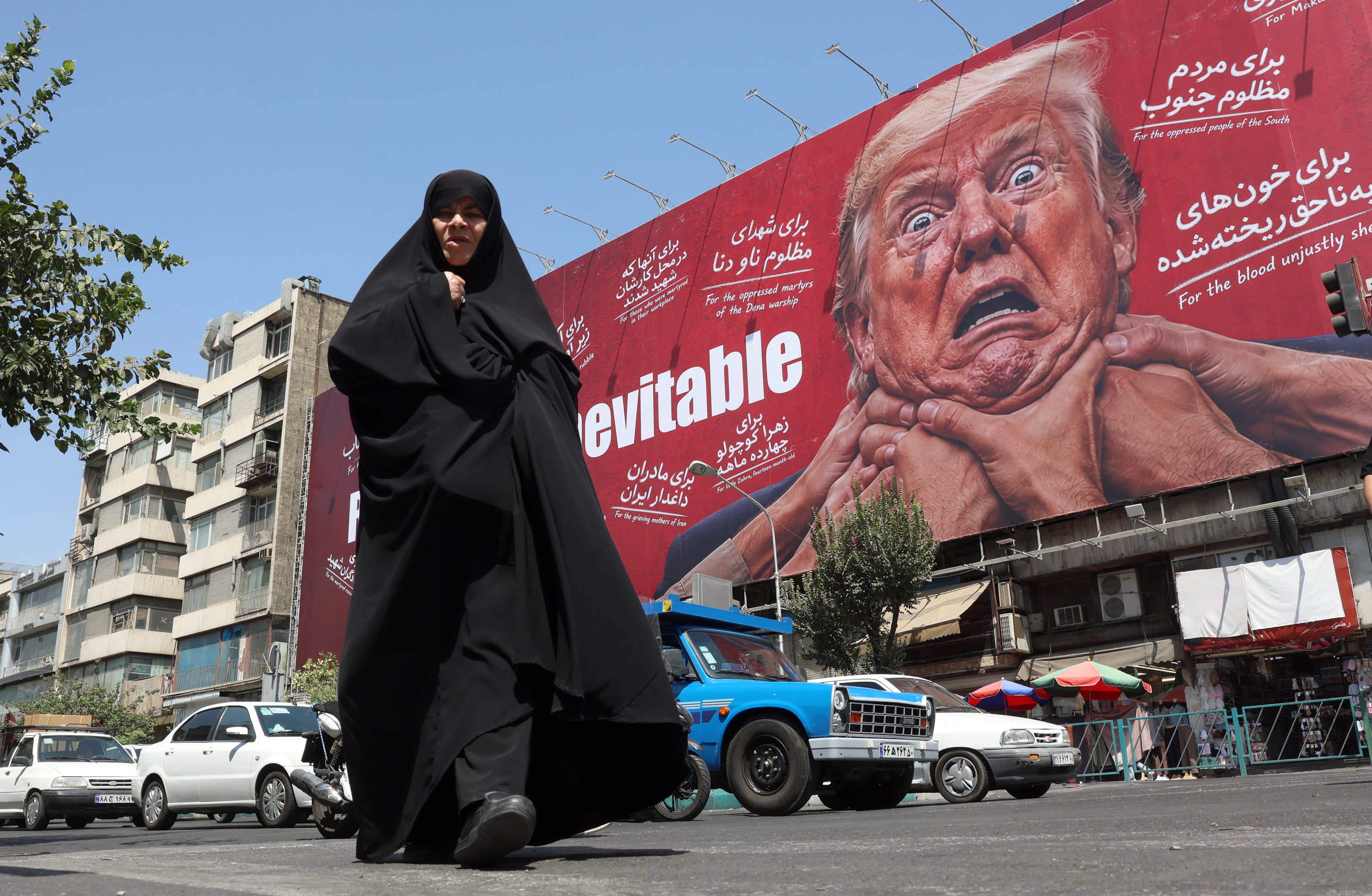 Pertsona bat Teheranen abuztuaren 19an, atzean Donald Trumpen kontrako hormairudi bat duela. ABEDIN TAHERKENAREH / EFE