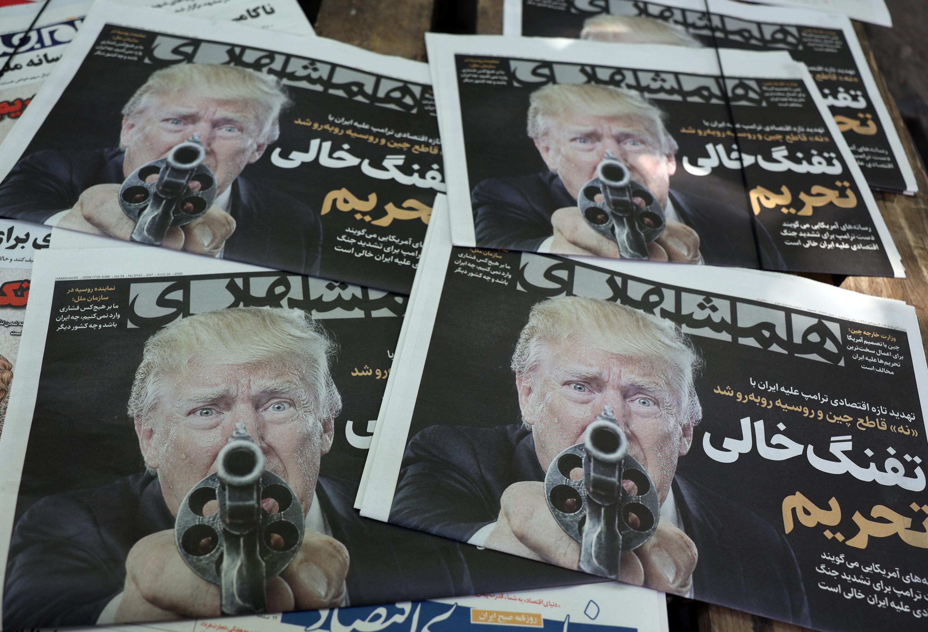 Trumpen irudi bat, pistola bat eskuetan duela, Irango egunkari batean, abuztuan. ABEDIN TAHERKENAREH / EFE