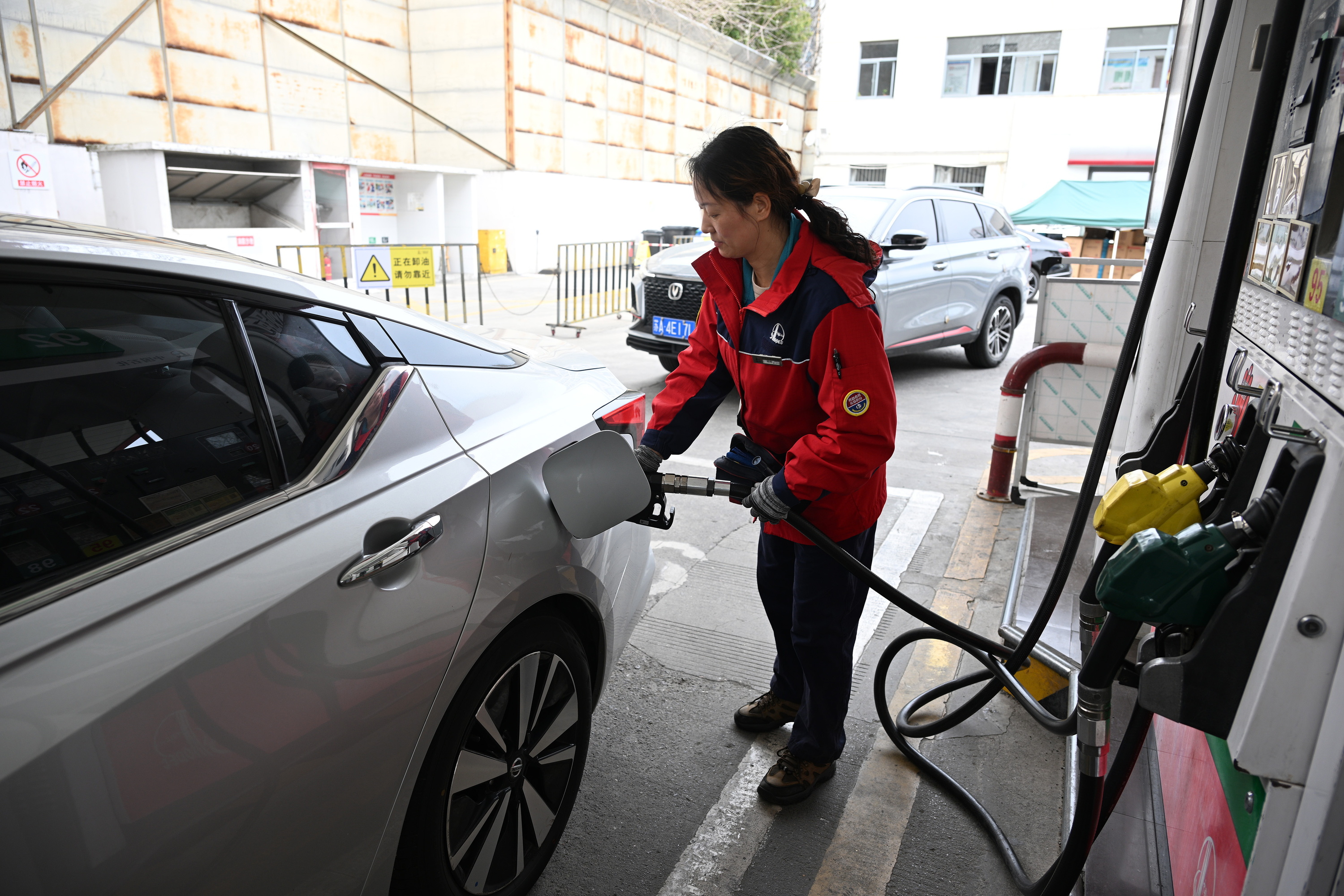 Nanjing hiriko gasolindegi bateko langile bat, auto baten depositua betetzen. FANG DONGXU / EFE