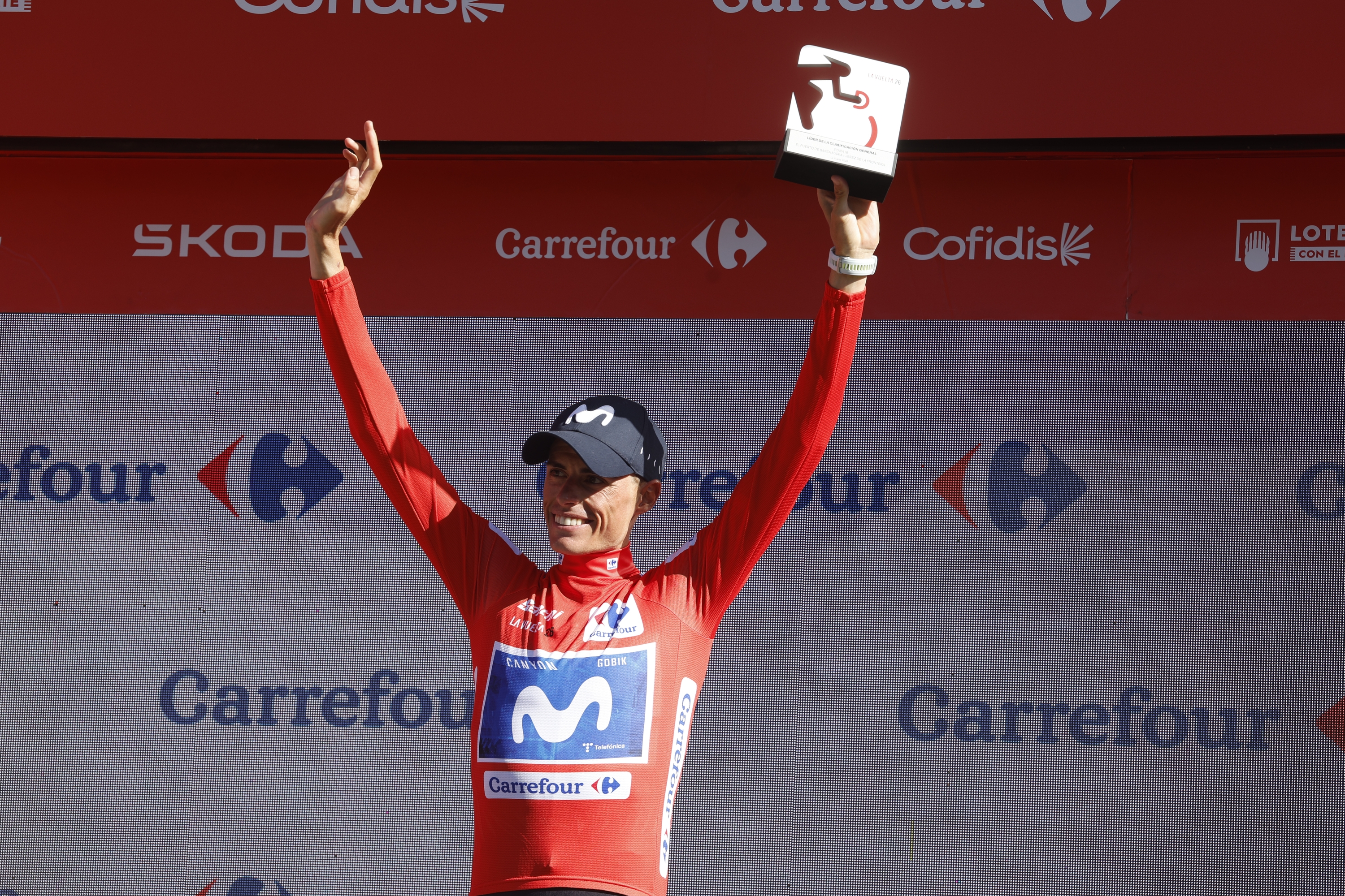 Enric Mas pozarren, podiumean, elastiko gorriarekin. JAVIER LIZON / EFE