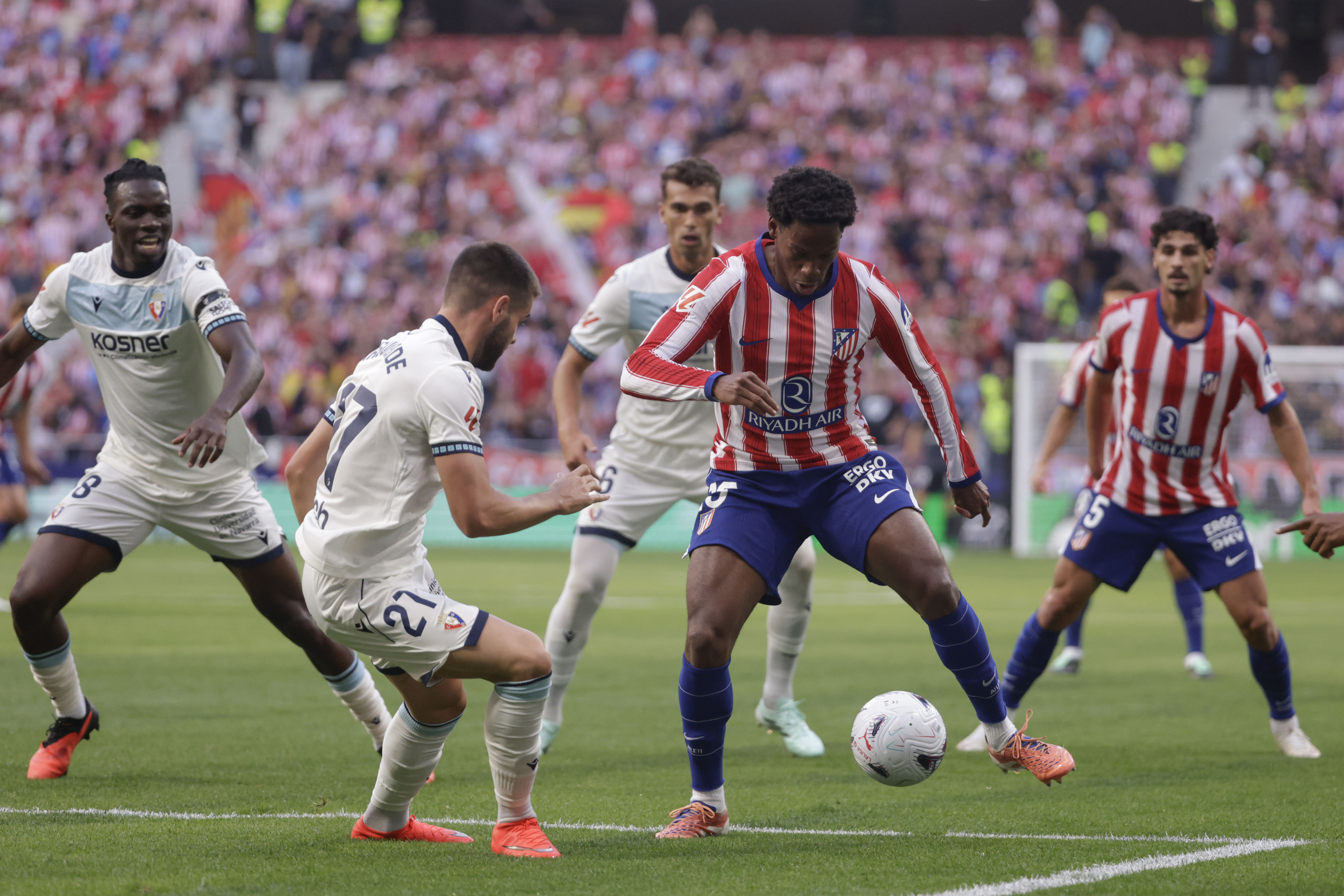 Osasunako jokalariak Atletico Madrileko Jonathan Davidi baloia kendu nahian. JUANJO MARTIN / EFE