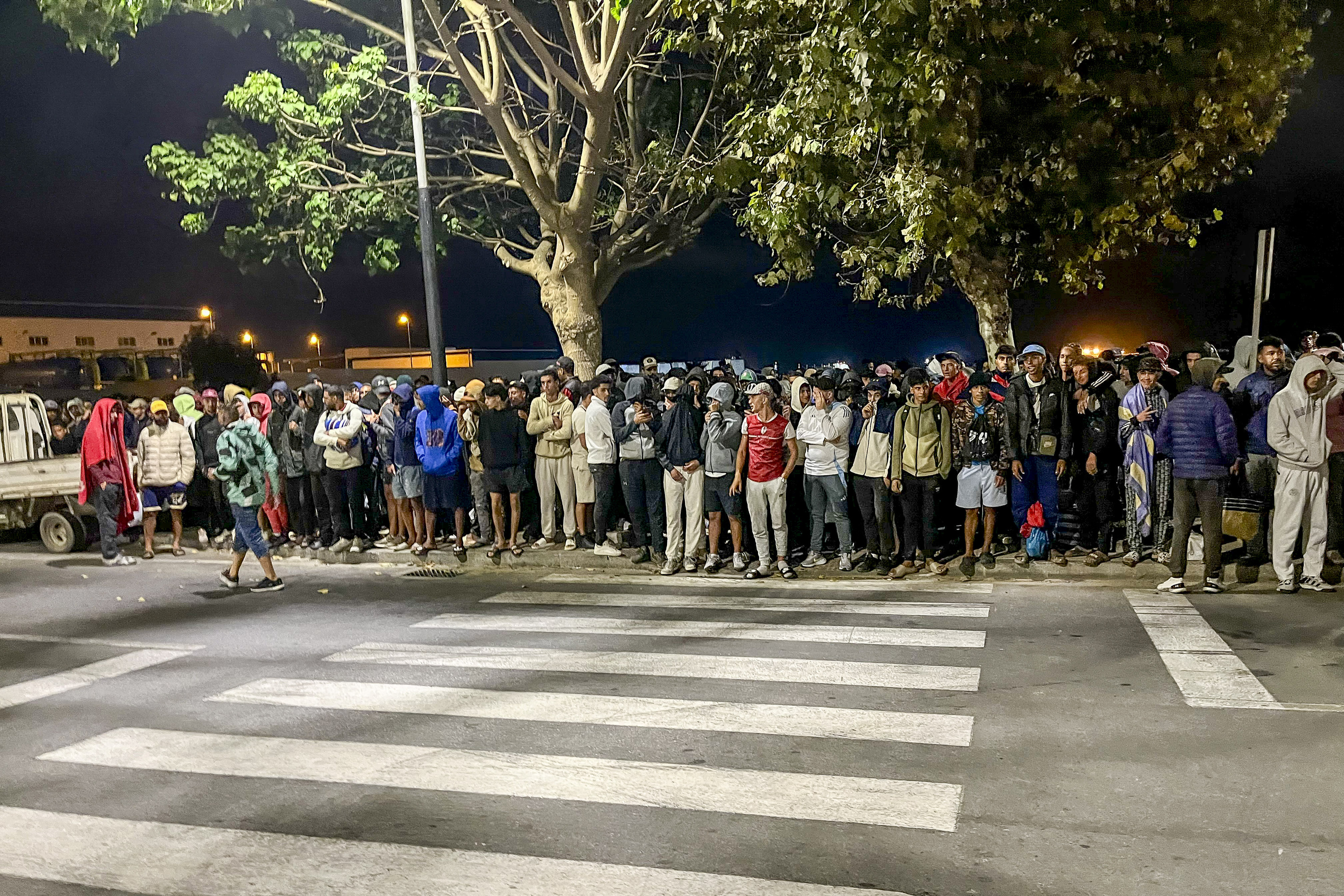 Ehunka migrante portuan jarritako kanpalekura joateko zain, gaur. REDUAN / EFE