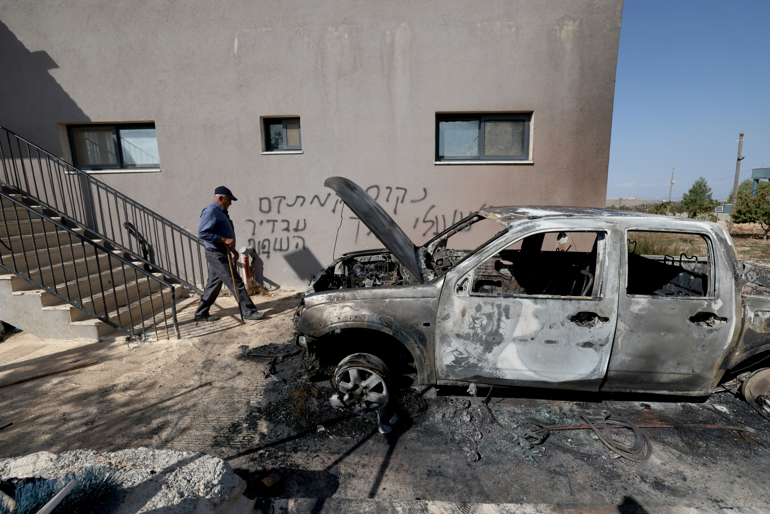 Kolonoek erretako auto bat, atzean Israelen aldeko pintada bat daukala, Ramallahn, Palestinako familia baten etxean. ALAA BADARNEH / EFE