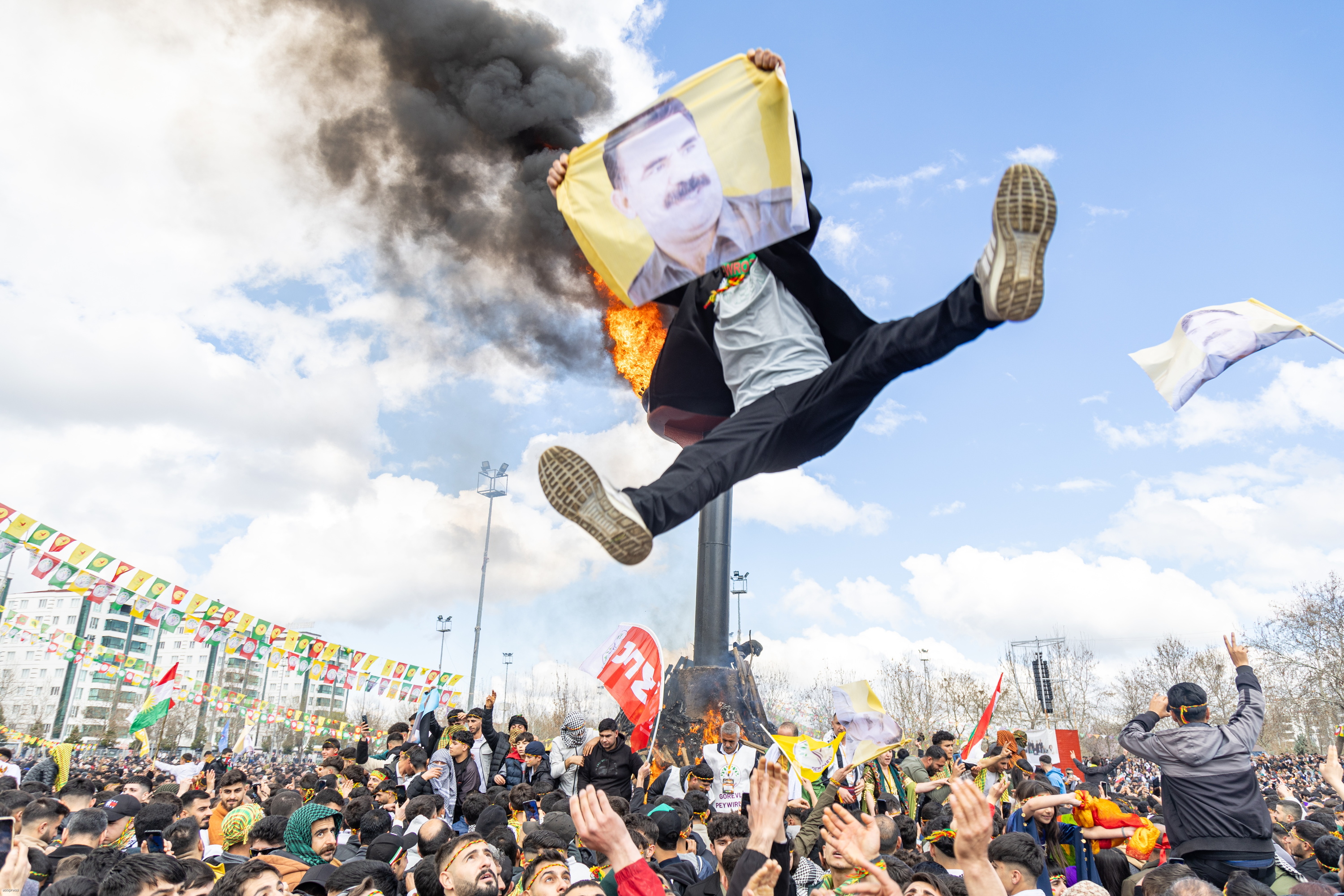 DEM alderdiaren jarraitzaile bat airean Diyarbakirren, 2023ko Newroz egunean, martxoaren 21ean, Ocalanen irudia duen oihal bat eskuetan duela. METIN YOKSU / EFE