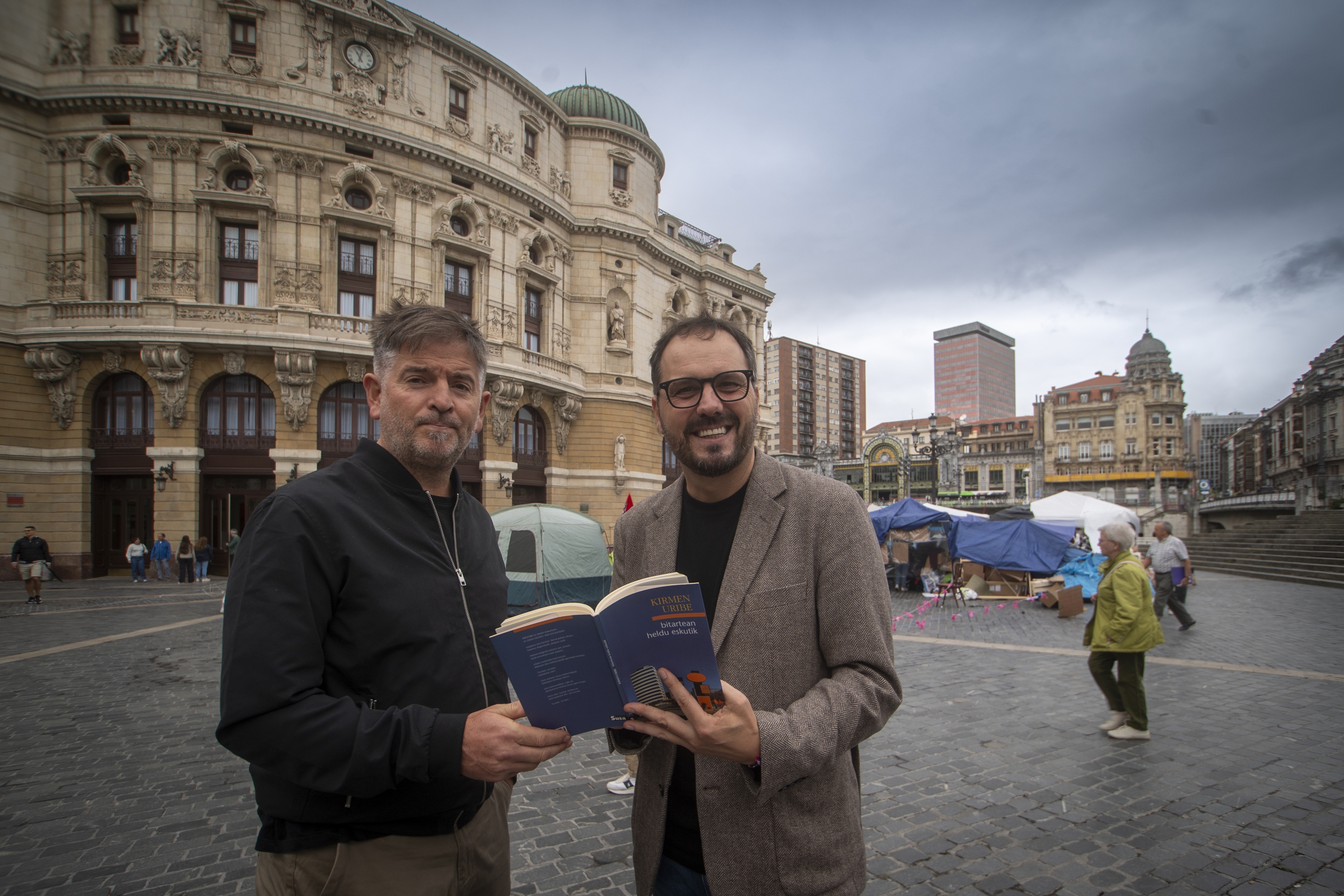 Mikel Urdangarin eta Kirmen Uribe, Bilboko Arriaga antzoki aurrean, 'Bitartean heldu eskutik' liburuarekin. GORKA RUBIO / FOKU