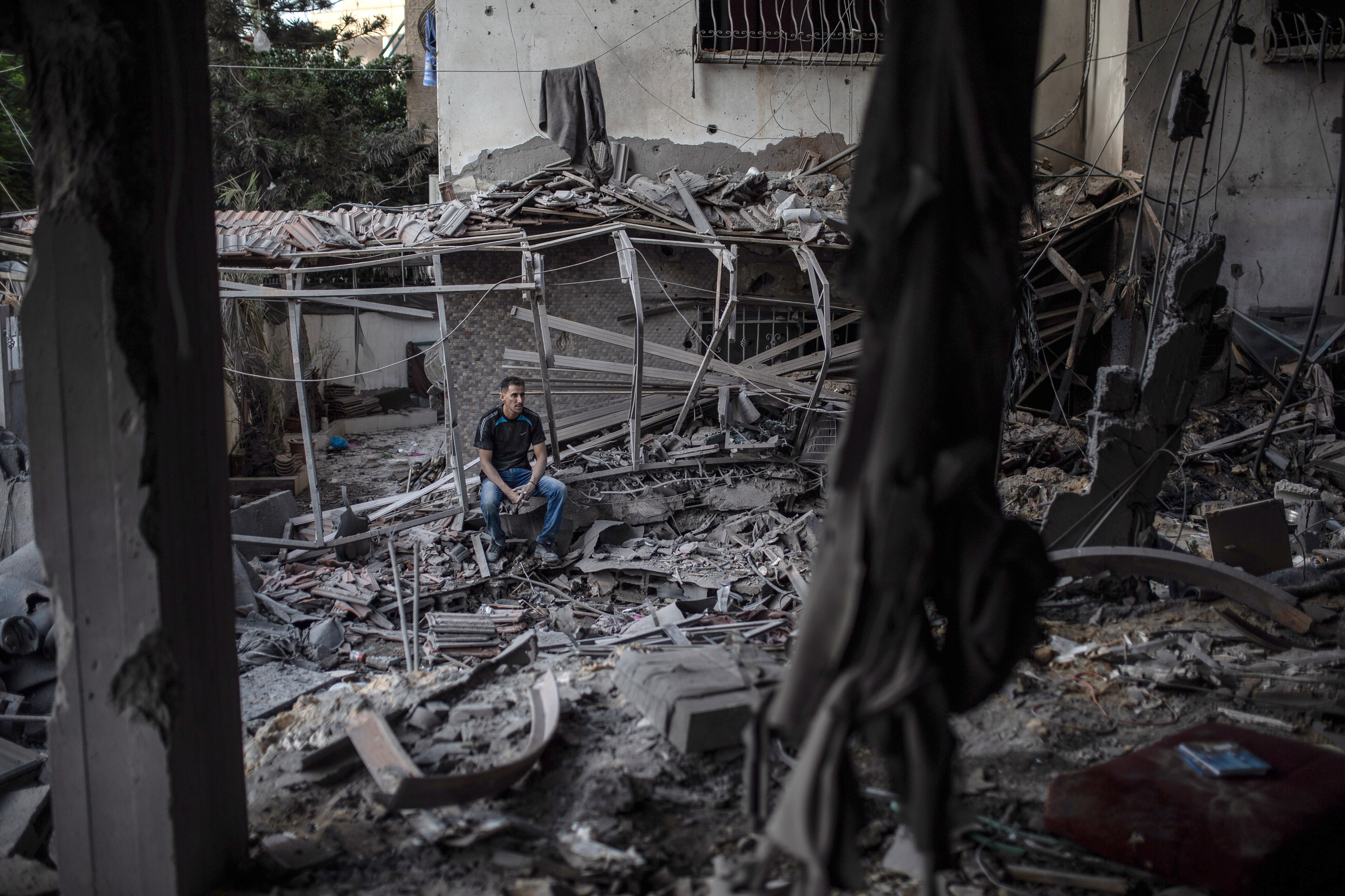 Gizon bat Gazan eroritako eraikin baten hondakinei begira, larunbatean. MOHAMMED SABER / EFE