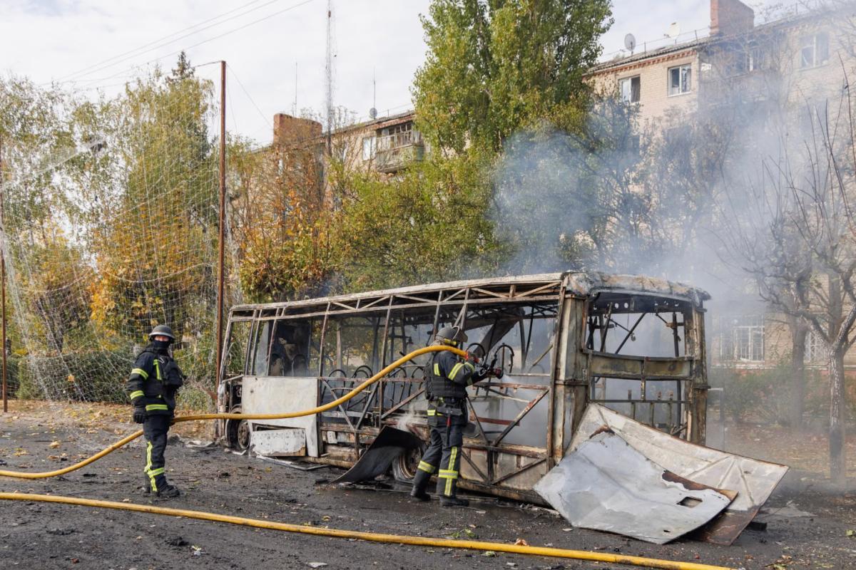 Suhiltzaileak Errusiak Donetsken egin duen erasoan kiskali duten autobus batean, lanean, gaur goizean. EFE