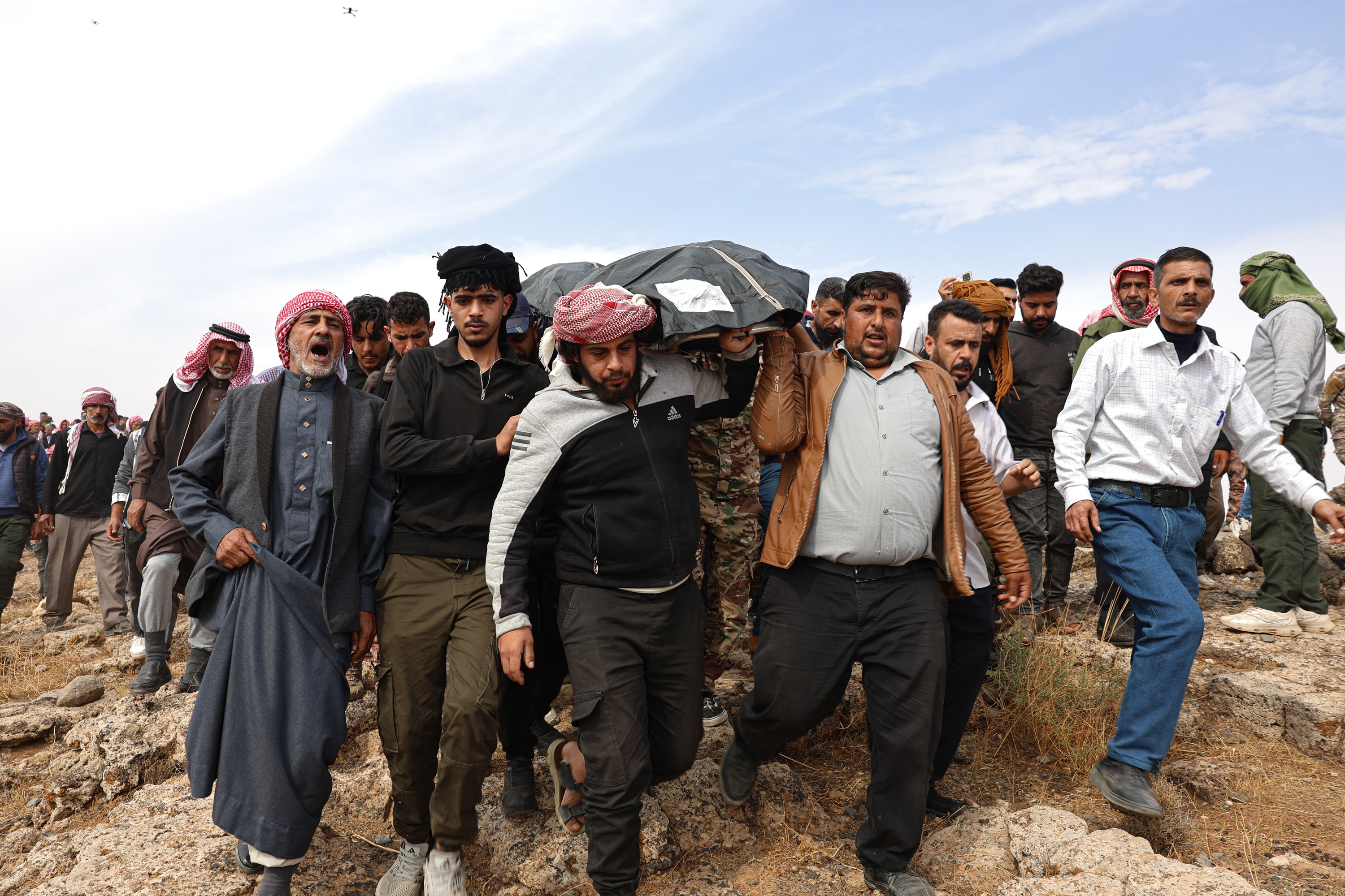 Pertsona batzuk Sirian gaur, Jordaniak eragindako hildako baten gorpua eramaten. MOHAMMED AL RIFAI  / EFE
