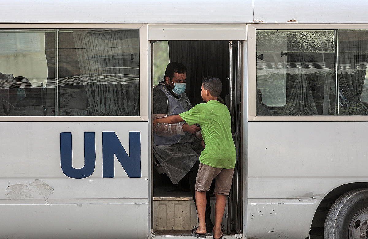 UNRWAko ibilgailu bat janaria banatzen Gazako herritarren artean. MOHAMMED SABER, EFE
