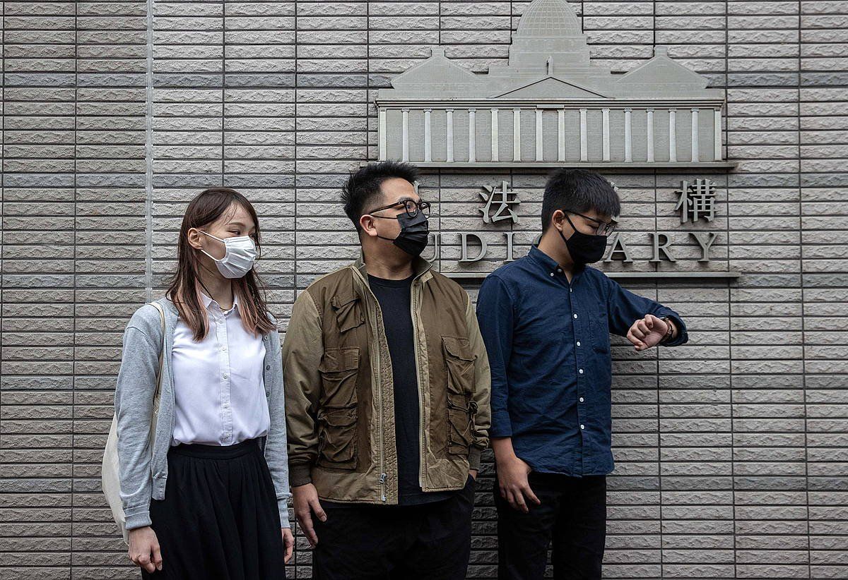 Agnes Chow, Ivan Lam eta Joshua Wong oposizioko ekintzaileak, zigortu dituen Hong Kongeko epaitegiaren aurrean, joan den azaroren 23an. JEROME FAVRE, EFE