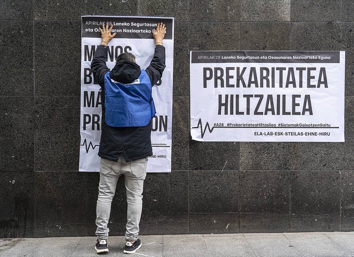 Sindikatu bateko kide bat prekaritatea salatzen duten afixak itsasten. ARITZ LOIOLA / FOKU Sindikatu bateko kide bat prekaritatea salatzen duten afixak itsasten. ARITZ LOIOLA / FOKU