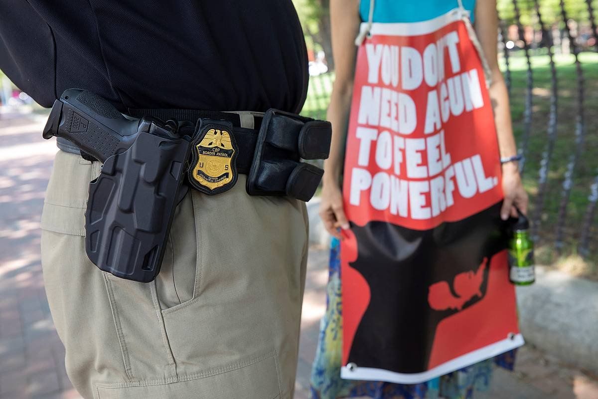 Polizia bat armen kontrolaren aldeko manifestari batekin hizketan, 2019an, Washingtonen (AEB). ERIK S. LESSER / EFE